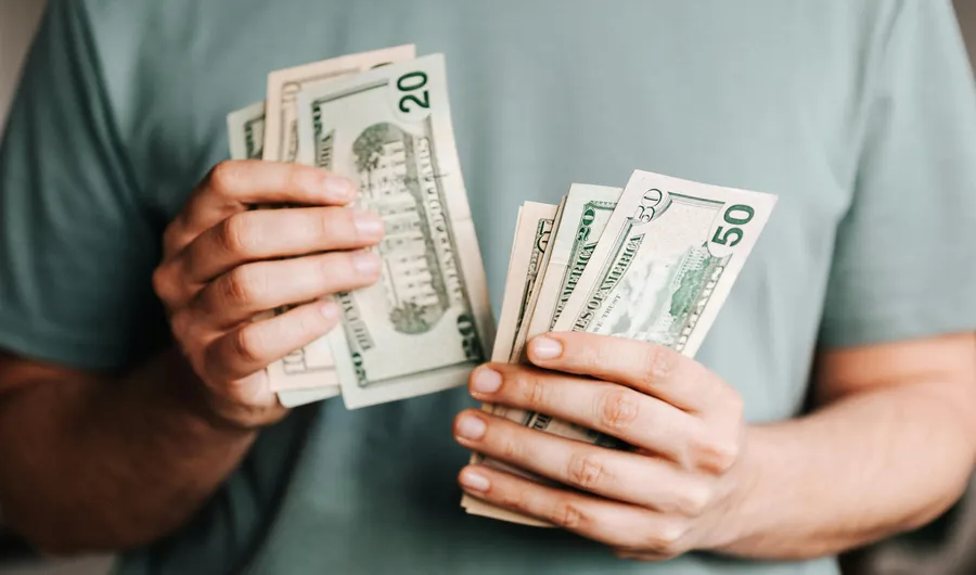 a man holding pre-settlement funding in the form of cash in hands
